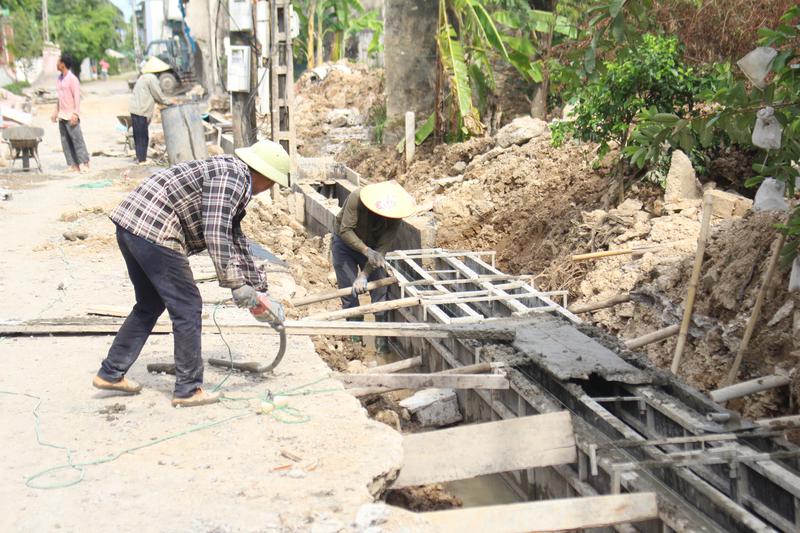 Phối hợp thi công hệ thống mương thoát nước tại thôn 12, xã Quỳnh Hưng. Ảnh: CTV