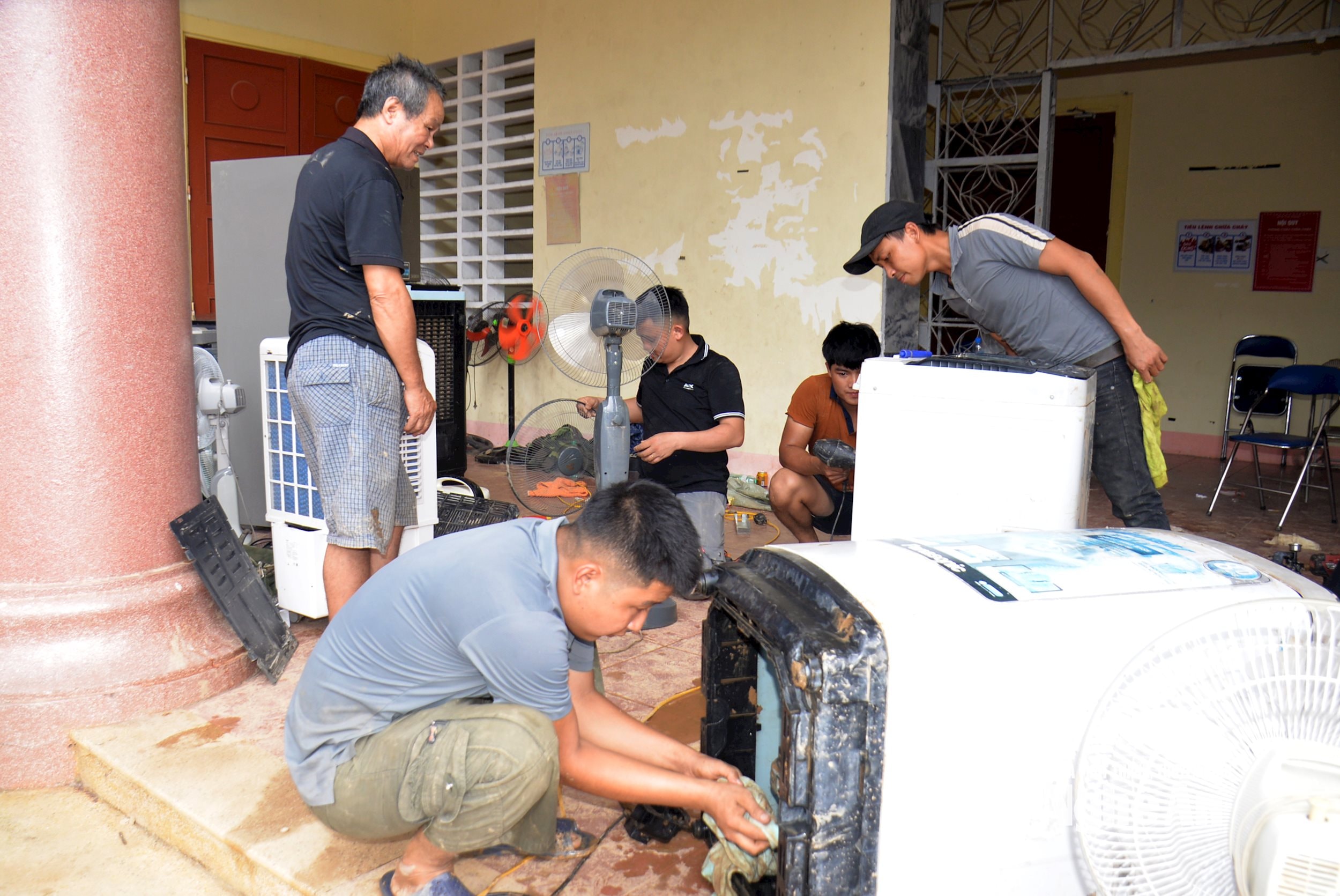 Với những thiết bị không thể phục hồi, đội ngũ kỹ thuật cũng tận tình hướng dẫn bà con cách xử lý, thay thế hoặc dùng tạm phương án khác để đảm bảo sinh hoạt. Ảnh: Quang An