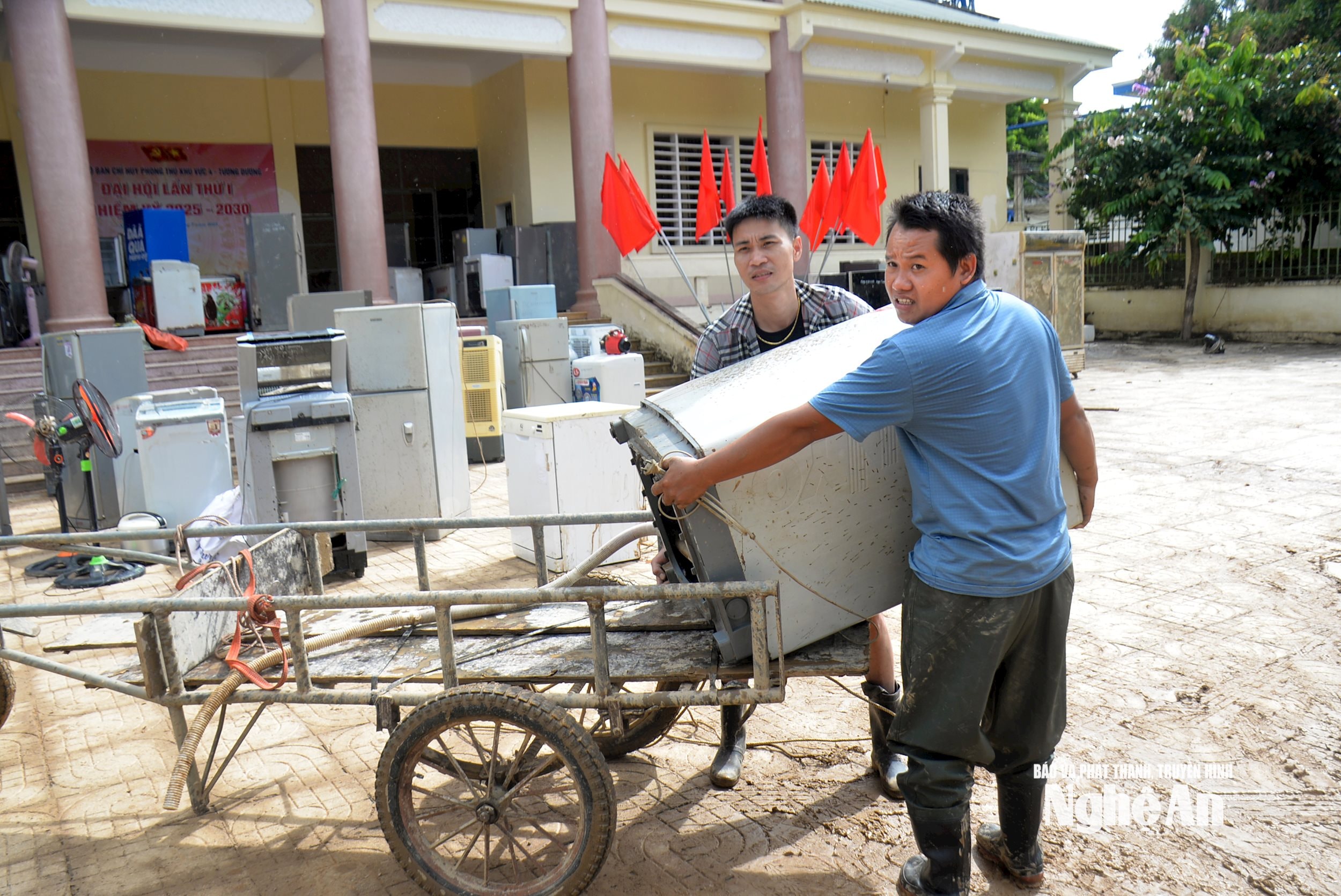 Ông Lô Văn Thông ở khối Hòa Bắc, xã Tương Dương cho biết, sau khi nước lũ rút, gia đình có 6 thiết bị điện: ti vi, tủ lạnh, quạt, máy giặt, máy bơm, không hoạt động được. Nghe tin có đội thợ sửa chữa miễn phí, gia đình vận chuyển đén đây, mong được giúp đỡ. Ảnh: Xuân Hoàng