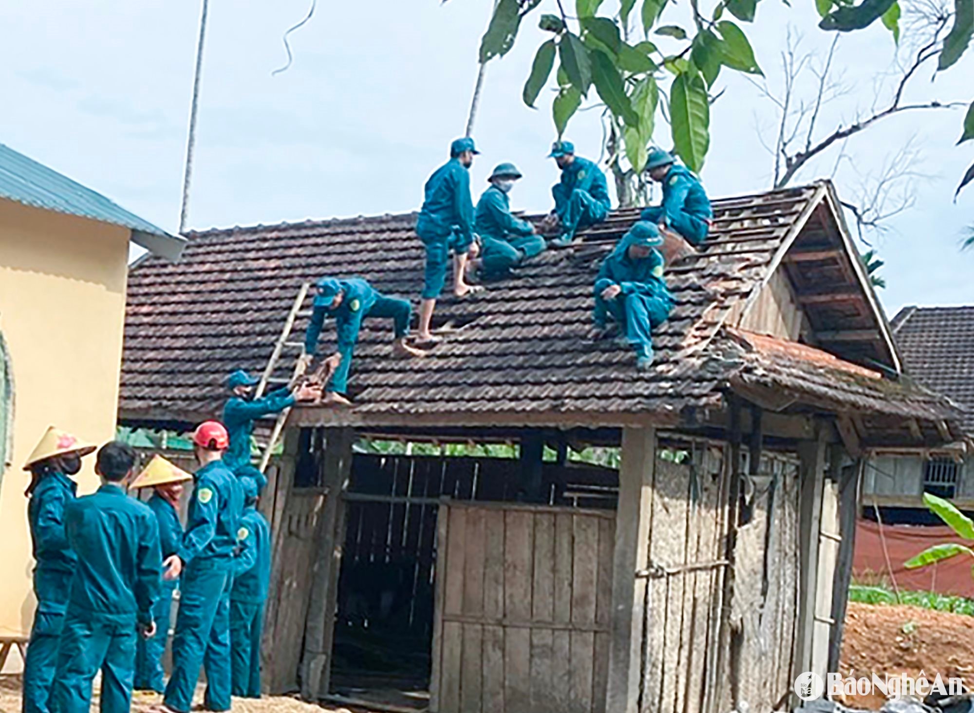 Xã Mậu Đức (Con Cuông) huy động lực lượng dân quân tự vệ hỗ trợ người dân phá dỡ nhà cũ, xây dựng nhà mới. Ảnh: Mai Hoa